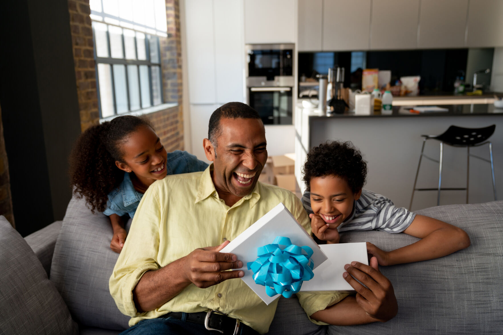 Happy kids surprising their father with a gift for Father's Day